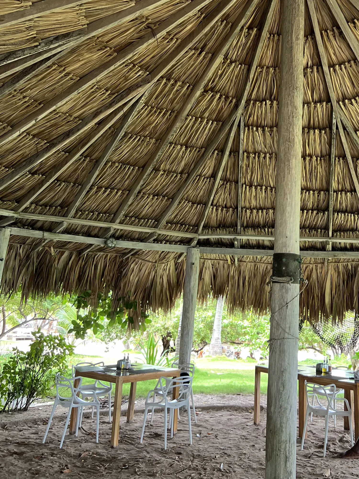 Tables under a thatched umbrella on the lawn