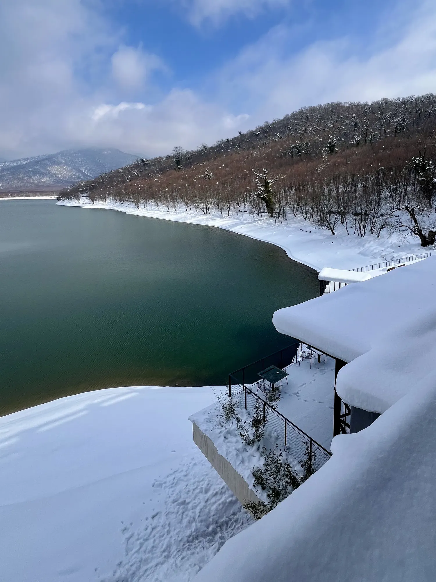 The lake curving under wooded hills