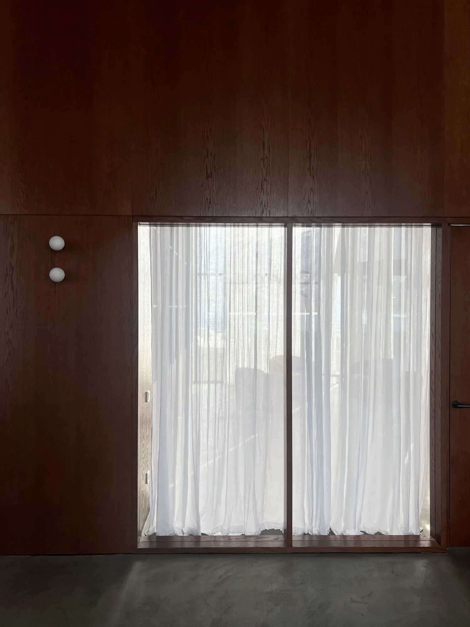 A wood wall and a curtained window