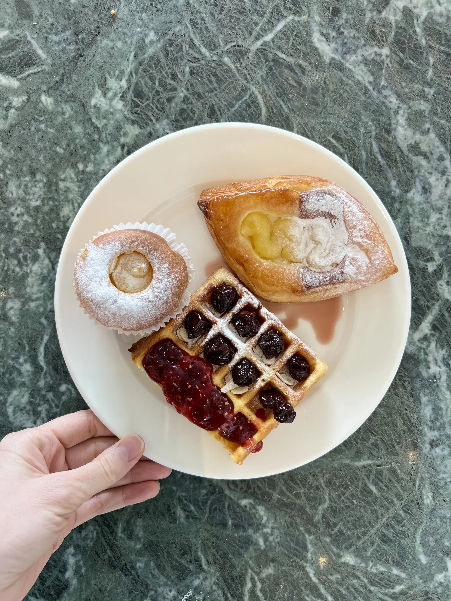 Pastries and a waffle on green marble
