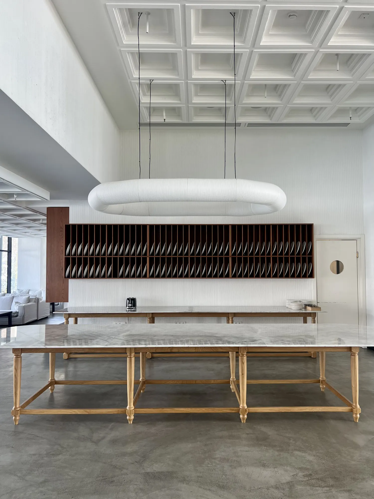 A long marble table under an oval lamp
